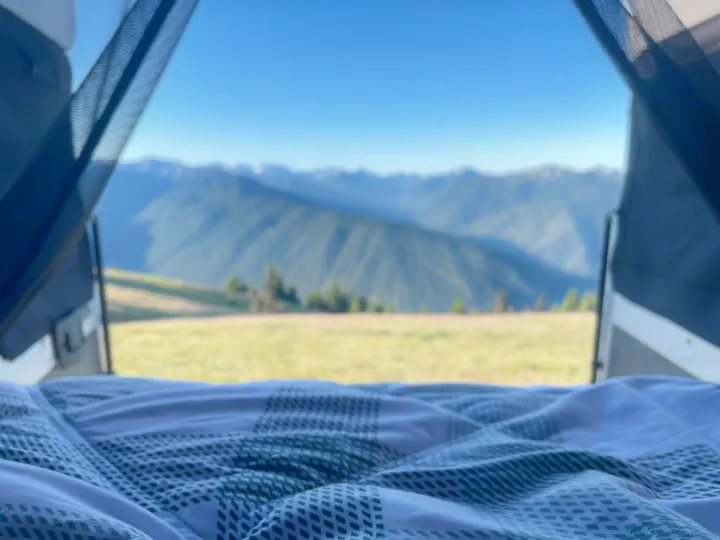 Wake up to epic mountain views from a comfortable RV rental bed! Lush green fields, distant peaks, and a vast blue sky await.. Other Other 2022