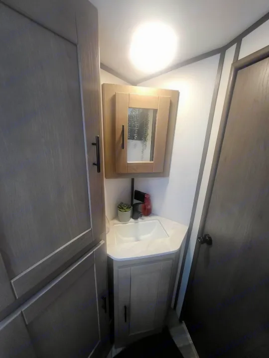 This RV rental features a compact bathroom with a corner sink, cabinet, and mirrored medicine cabinet, ideal for travel.. Cruiser Rv Corp Shadow Cruiser 2021