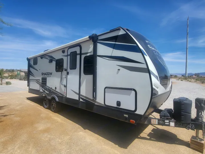 This white Shadow Cruiser travel trailer, ideal for RV rental, is parked outdoors on a sunny day under a bright blue sky.. Cruiser Rv Corp Shadow Cruiser 2021