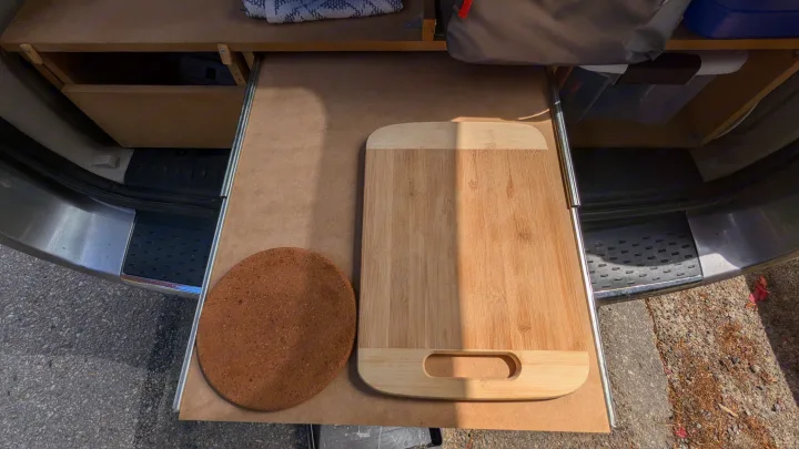 RV rental kitchen setup: pull-out shelf with cutting board & cork mat for compact outdoor cooking.. Dodge Grand Caravan 2014
