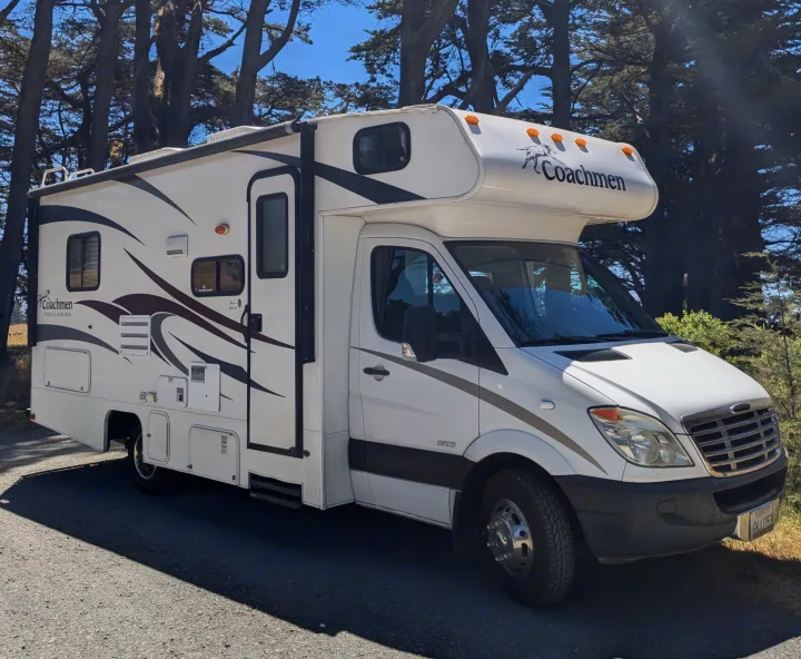 This white Coachmen RV rental is parked among tall trees, ready for an outdoor travel adventure.. Forester Forester Motorhome 2019