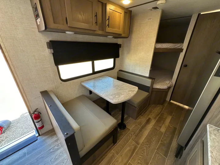 Step inside this rv rental featuring a compact dinette, overhead storage, and comfortable bunk beds.. Gulf Stream Kingsport 2022