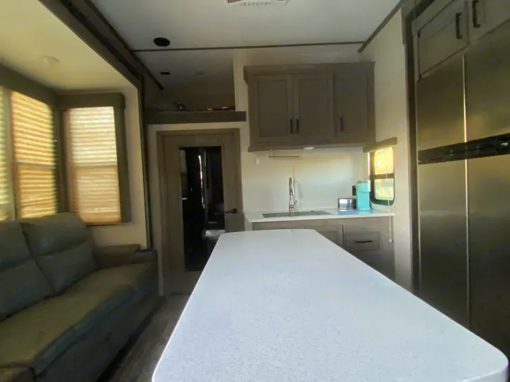Experience comfort in this modern rv rental. Spacious interior with full kitchen, island, living area sofa, and large fridge.. Keystone Carbon 2020