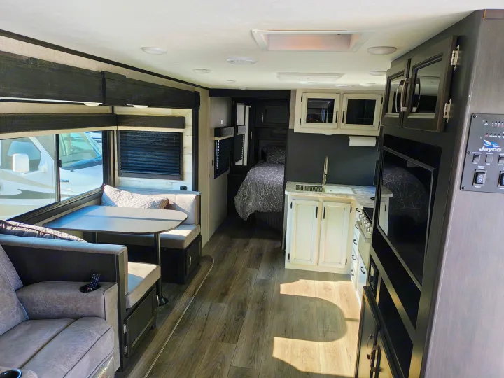 Explore this RV rental's spacious interior: a modern kitchen, cozy dinette, comfortable living area, and private bedroom await.. Jayco JAY FEATHER 26RB 2021