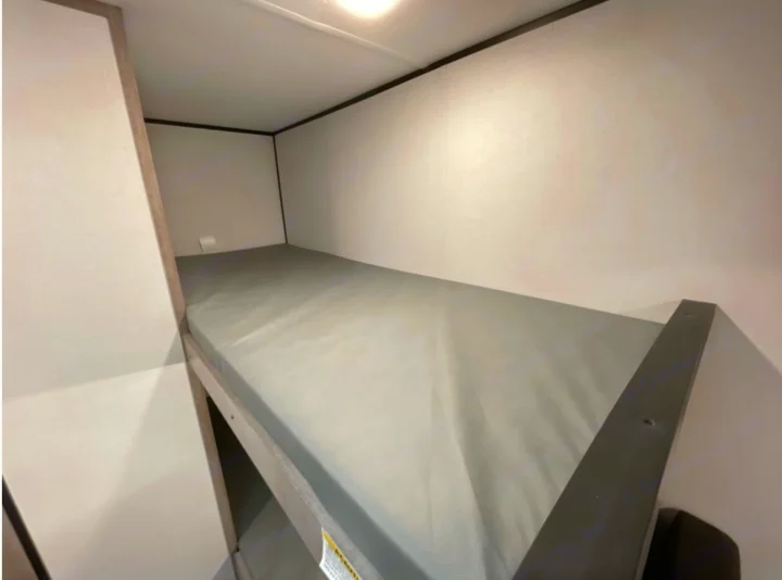 RV rental: Interior view of compact bunk beds with gray mattresses.. Coleman 17B 2023