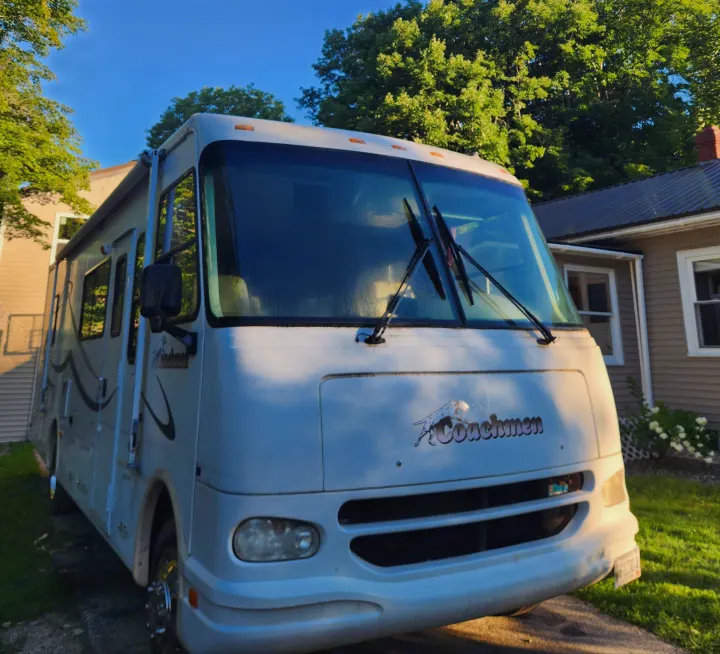 Front view of a white Coachmen RV parked on a sunny day, ideal for an rv rental adventure or family road trip.. Coachmen Mirada 2002