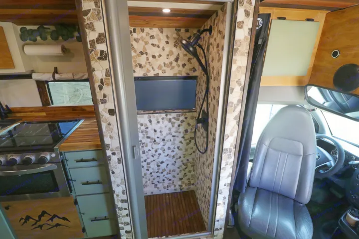 RV rental with custom mosaic-tiled shower, wood kitchen counters, and spacious front cabin seating.. Chevrolet Express 2011