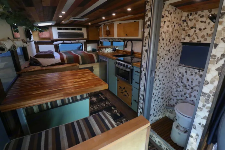 Fully equipped RV rental interior: wood-paneled ceiling, kitchen, bedroom, dining table, and tiled shower/toilet.. Chevrolet Express 2011