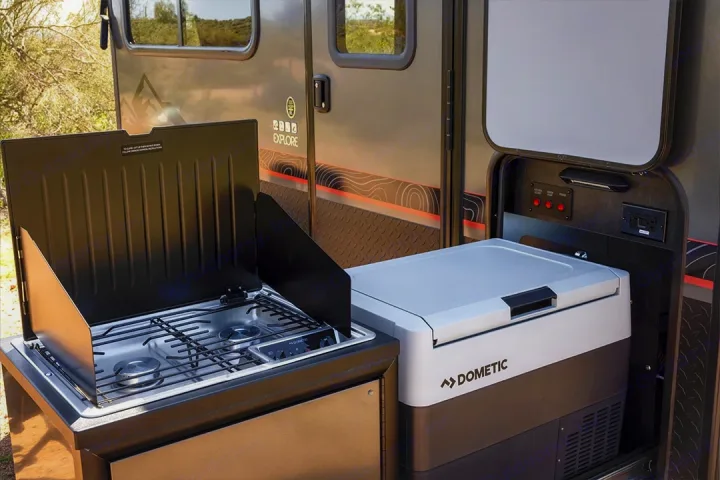 Perfect RV rental setup: outdoor kitchen with Dometic two-burner stove, portable fridge, and power panel for easy camping.. Intech Explore 2023