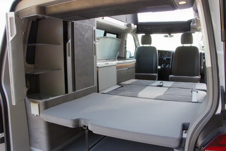 Discover this versatile camper van interior for your next rv rental, featuring a bed, kitchen, and smart storage.. Volkswagen California Ocean 2025