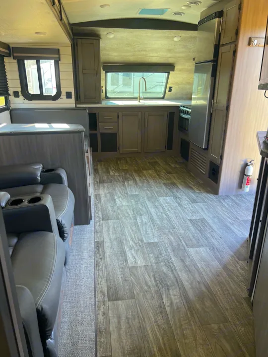 Modern RV rental interior, featuring a well-equipped kitchen, dinette, and comfortable recliners for your travels.. Crossroads sunset trail superlite 2022