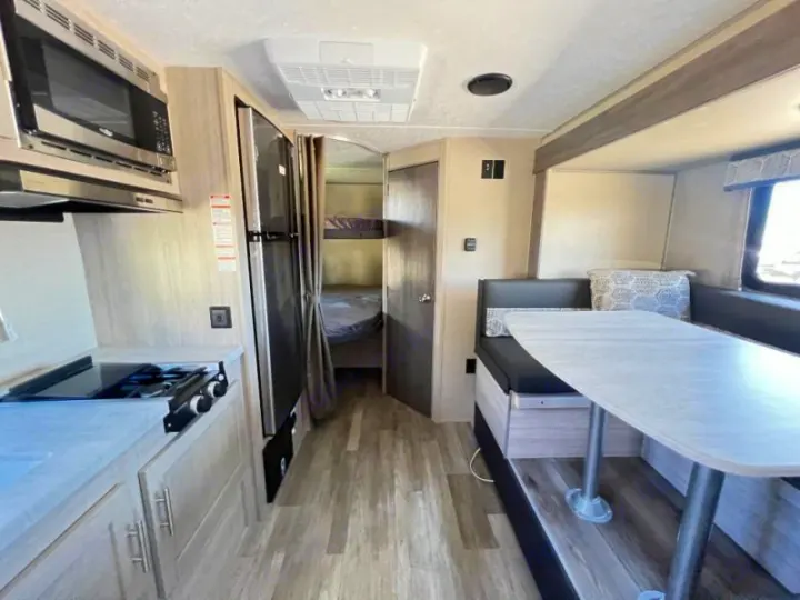 Spacious RV rental interior features a modern kitchen, cozy dinette, and convenient bunk beds for your travels.. Coachmen Catalina 2022
