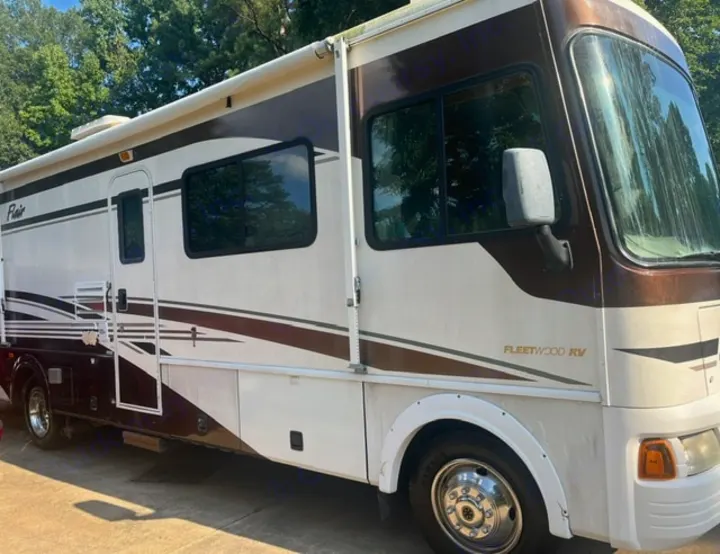 This brown & white Class A motorhome, a Fleetwood RV, is featured for rv rental. Explore travel adventures!. Fleetwood Flair 31A 2005
