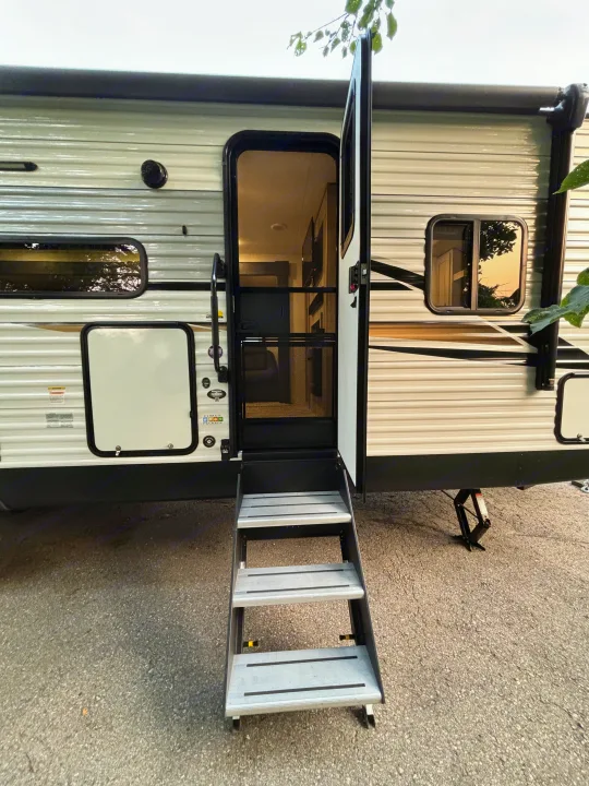 Open door of an RV rental with stairs extended, showing the interior. Ready for adventure.. Sportsmen 261BHKSE 2024