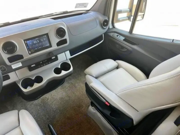 Experience comfort in this RV rental's front cabin. Modern dashboard with multimedia, cozy gray seats, ample cup holders.. Thor Quantum 2022
