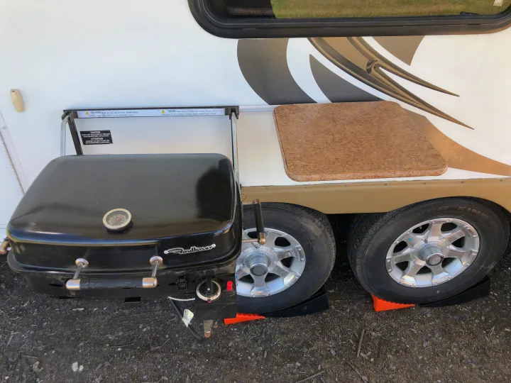 RV rental with an attached portable grill and counter for convenient outdoor cooking. Wheels are on leveling blocks.. Forest River Rockwood Mini Lite 2012