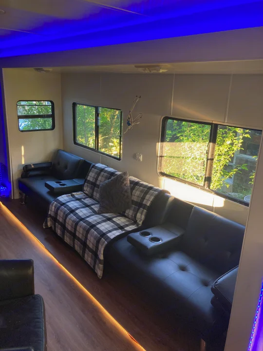 Relax in this modern RV rental lounge with black leather sofas, accent lighting, and scenic views from large windows.. Monaco Monarch SE 2006