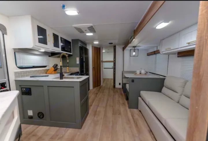 This RV rental's modern interior showcases a compact kitchen, dinette, and sofa. Comfort and convenience for your travels.. Heartland RVs Eddie Bauer BHS 34 2024