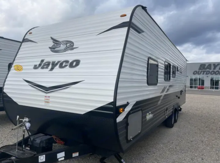 This white & black 2022 Jayco travel trailer is great for an RV rental. A new RV parked outdoors at a dealership.. Jayco Jay Flight 2022
