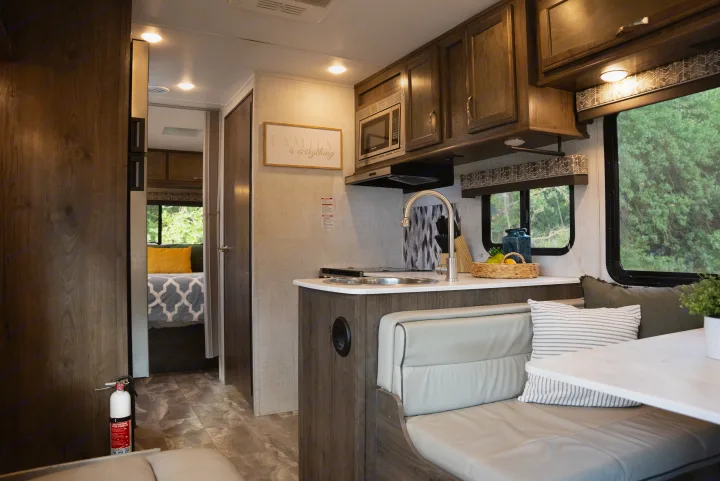 Enjoy this bright RV rental interior featuring a modern kitchen, comfortable dinette, and cozy bedroom.. Gulf Stream Conquest 2022