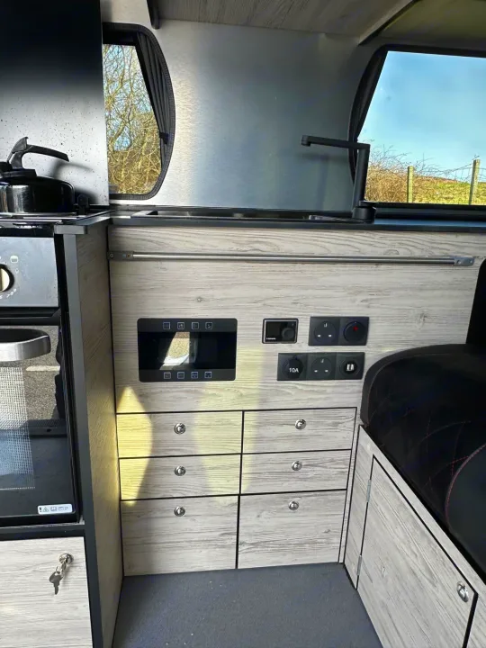 This RV rental shows a compact campervan interior with kitchen, controls, storage, and seating.. Renault Other 2023