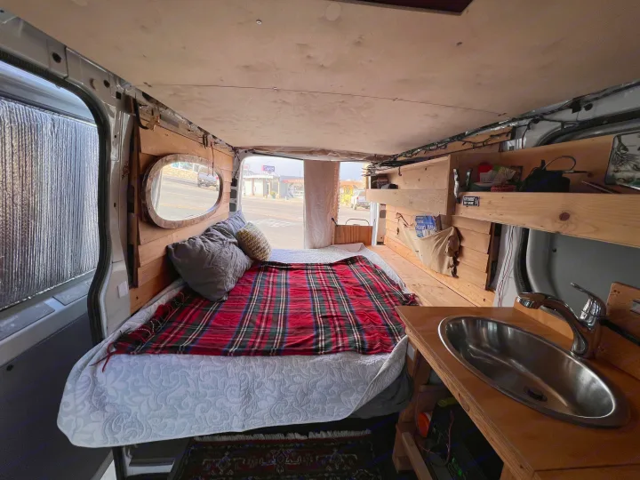 This custom camper van offers a cozy bed, sink, and wood interior. Ideal for an rv rental road trip!. Mercedes-Benz Sprinter 2012