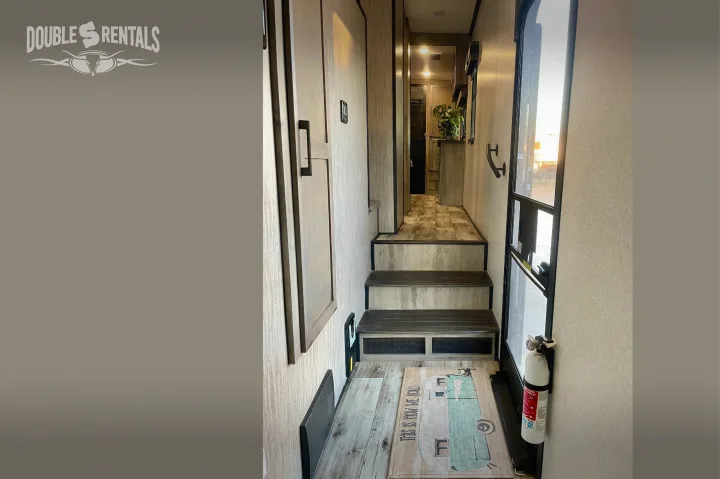 Explore this spacious RV rental interior: a functional hallway with stairs leading up, and a fire extinguisher by the door.. KZ Durango Gold 2022