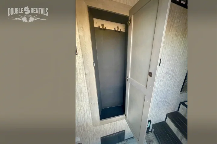 RV rental interior: Open closet with coat hooks, light wood walls, and steps for convenient storage in this cozy space.. KZ Durango Gold 2022