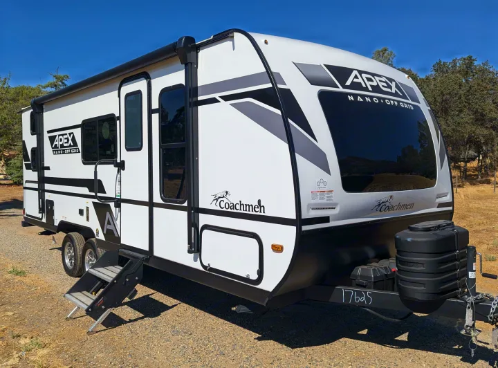 A sleek white and black Apex Nano Off Grid travel trailer, an ideal rv rental for your next outdoor adventure.. Coachmen Apex Nano 2024