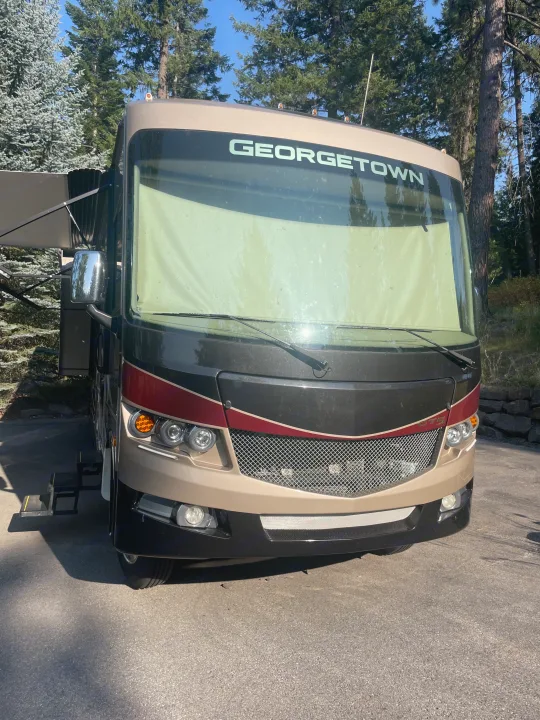 A Georgetown motorhome (RV) in front view, featuring a tan and black exterior with extended steps. Ideal for an RV rental.. Georgetown GT5 2019