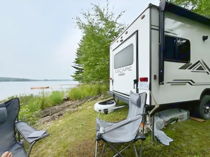 Scenic RV rental by a lake with camping chairs & tablet for a relaxing outdoor escape.. KZ Escape Hatch 2022