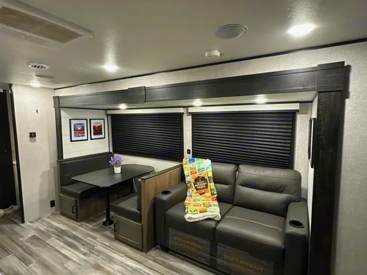 RV rental living space: comfy gray sofa & dinette with National Parks decor. Ideal for travel.. Jayco Jay Flight 2024