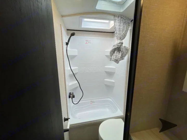 Cozy RV rental bathroom: compact white shower stall, handheld shower, and skylight. Ideal for road trips.. Jayco Jay Flight 2024