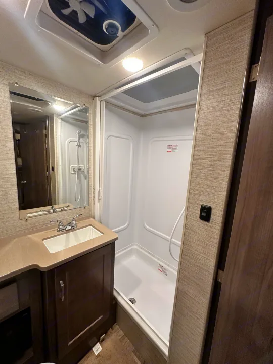 RV rental bathroom: A compact space with a sink, mirror, and shower, designed for comfortable travel.. Winnebago Minnie Winnie 2022