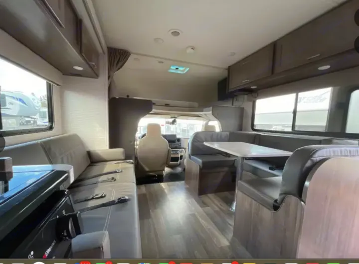 Spacious RV rental interior with a comfortable sofa, dinette, and driver's cabin access, ready for adventures.. Winnebago Minnie Winnie 2022
