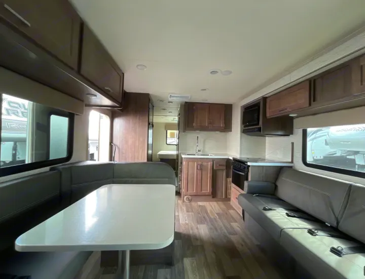 Spacious RV rental interior featuring a bright dinette, full kitchen, and comfortable sofa seating area.. Winnebago Minnie Winnie 2022