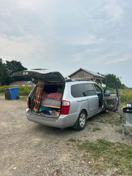 This converted minivan with a bed inside is ready for camping. A compact option like an RV rental for road trip adventures.. KIA SEDONNA 2008