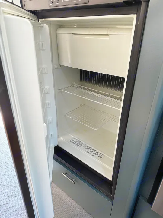 Clean, empty refrigerator with wire shelves & freezer inside an RV rental. Ready for your trip!. Airstream Custom 2006