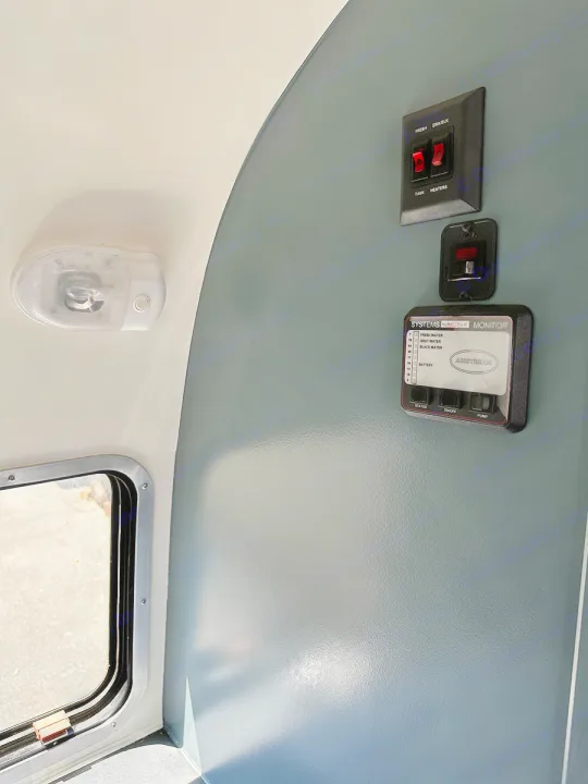 RV rental interior view: Airstream water/battery monitor, tank heater switches, and a ceiling light.. Airstream Custom 2006