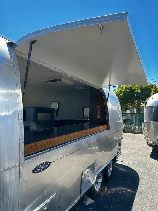 This converted Airstream Safari RV rental is a sleek mobile bar with its large serving window open, ready for events.. Airstream Custom 2006