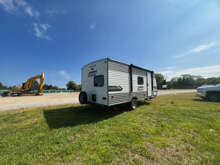 This Coleman RV rental, parked on grass near an excavator and storage units, is ready for your next outdoor adventure.. Coleman Lantern 18 2024