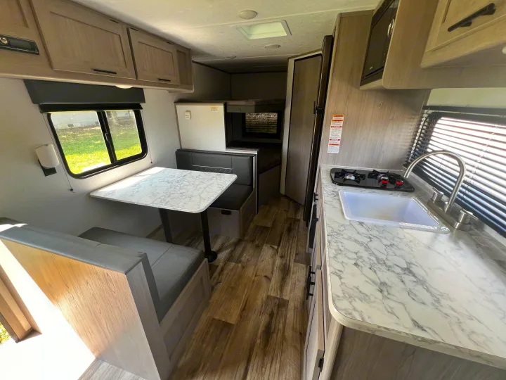 Step inside this modern rv rental, featuring a cozy dinette, well-equipped kitchen, and bunk beds for your travel adventure.. Coleman Lantern 18 2024