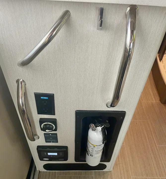 Inside an RV rental: grab handles, GFI outlet, battery switch, solar controller, and fire extinguisher.. Thor Tellaro 2022