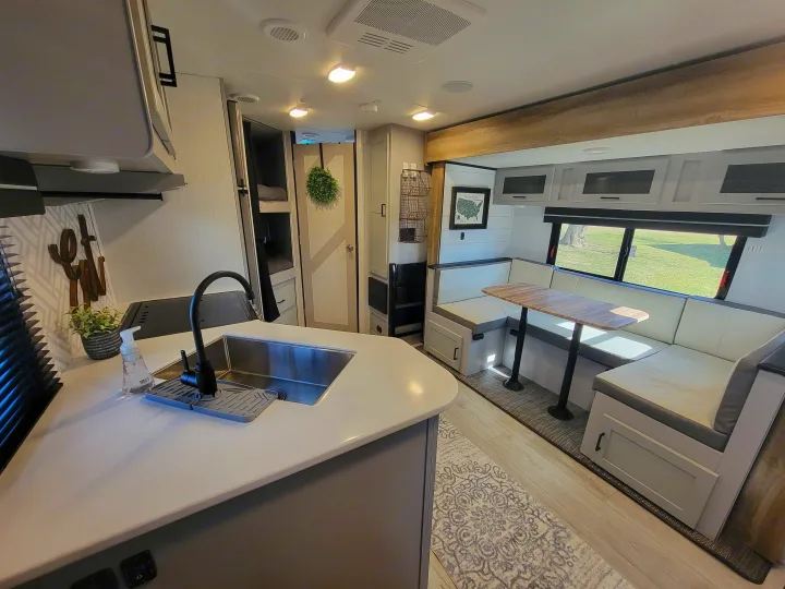 RV rental interior with a modern kitchen, cozy dining area, and bunk beds. Ideal for comfortable travel.. Heartland RVs North Trail 2023