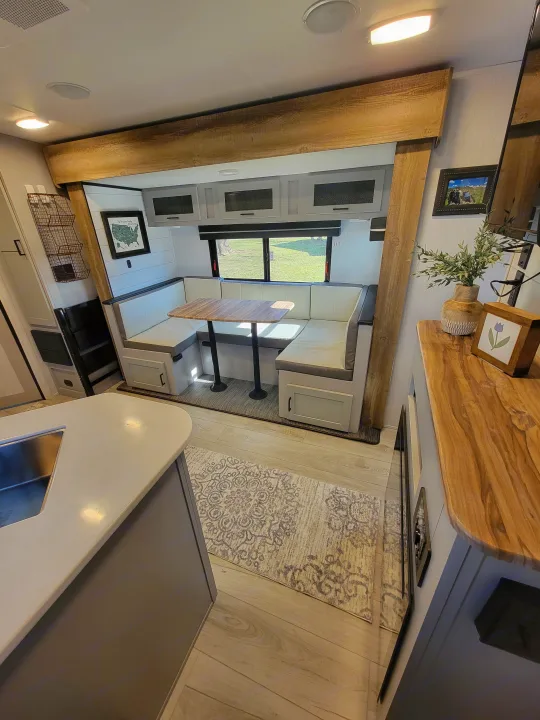 Spacious RV rental interior with modern dinette, kitchen, and ample light. Perfect for comfortable travel.. Heartland RVs North Trail 2023