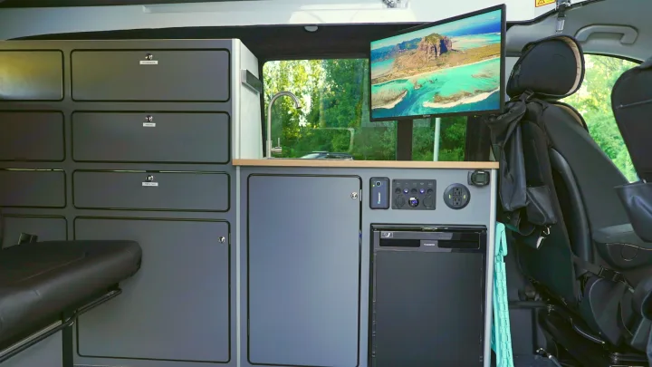 RV rental interior: kitchen with sink, fridge, labeled storage, power outlets, and a TV.. Mercedes-Benz Metris 2023