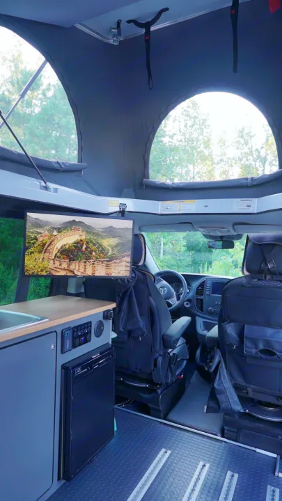 RV rental's spacious interior, showcasing a pop-top, full kitchenette, rotating seats, and TV for comfortable journeys.. Mercedes-Benz Metris 2023