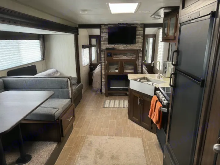 Spacious RV rental interior with a bright living area, full kitchen, and cozy bedroom. Ideal for family adventures.. Forest River Cherokee Grey Wolf 2020