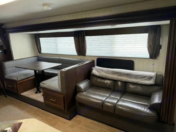 Spacious RV rental interior featuring a comfortable dinette with storage and a cozy sofa for relaxing.. Forest River Cherokee Grey Wolf 2020