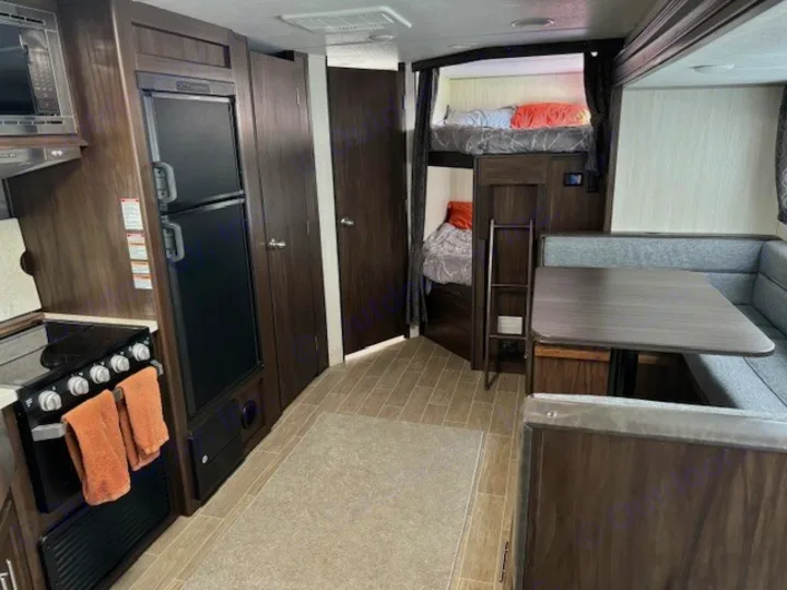 Spacious rv rental interior featuring kitchen, dining booth, and bunk beds. Perfect for family adventures.. Forest River Cherokee Grey Wolf 2020